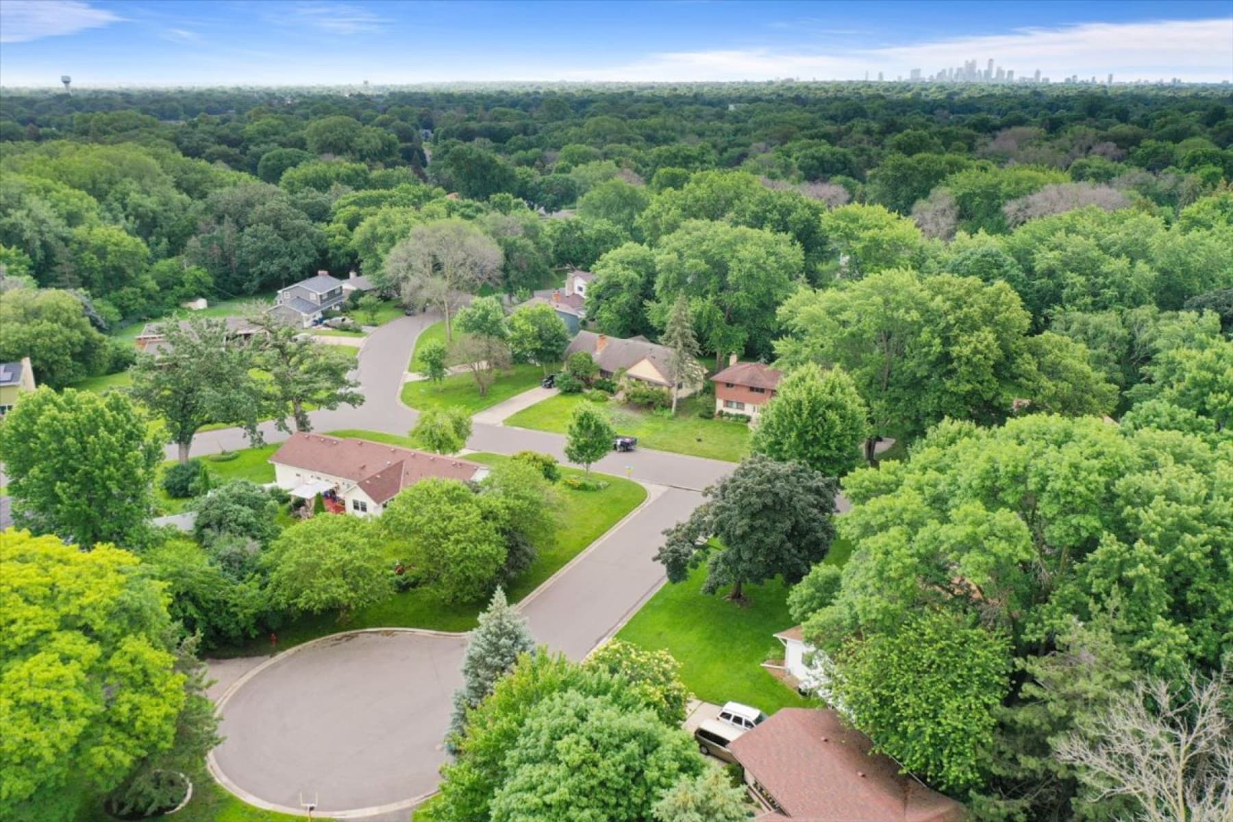Aerial view of a Twin Cities suburban neighborhood with the Minneapolis skyline in the distance